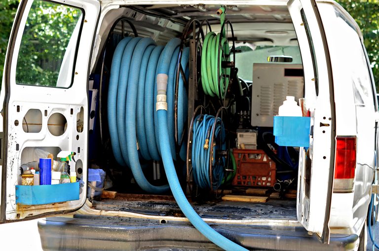 A van with equipment in the back for cleaning carpet.